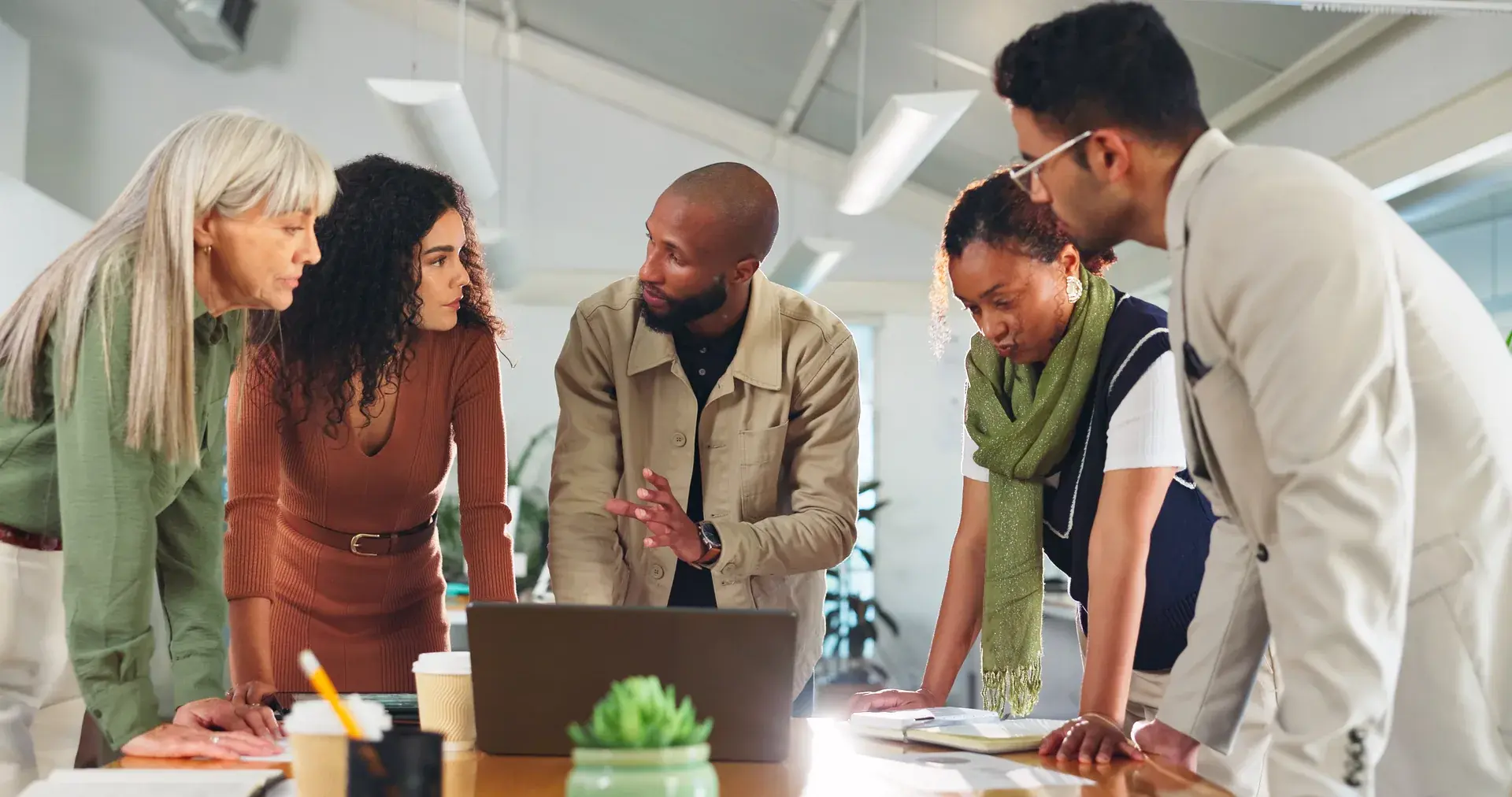 Marketing team gathered around a laptop planning a personalization program
