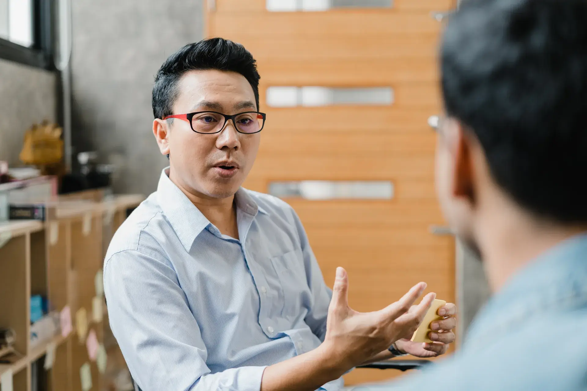 Two people in conversation, one gesturing as he explains a point