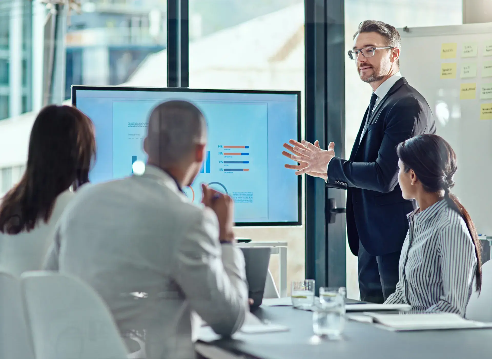 Consultant presenting performance charts to financial services executives in a boardroom