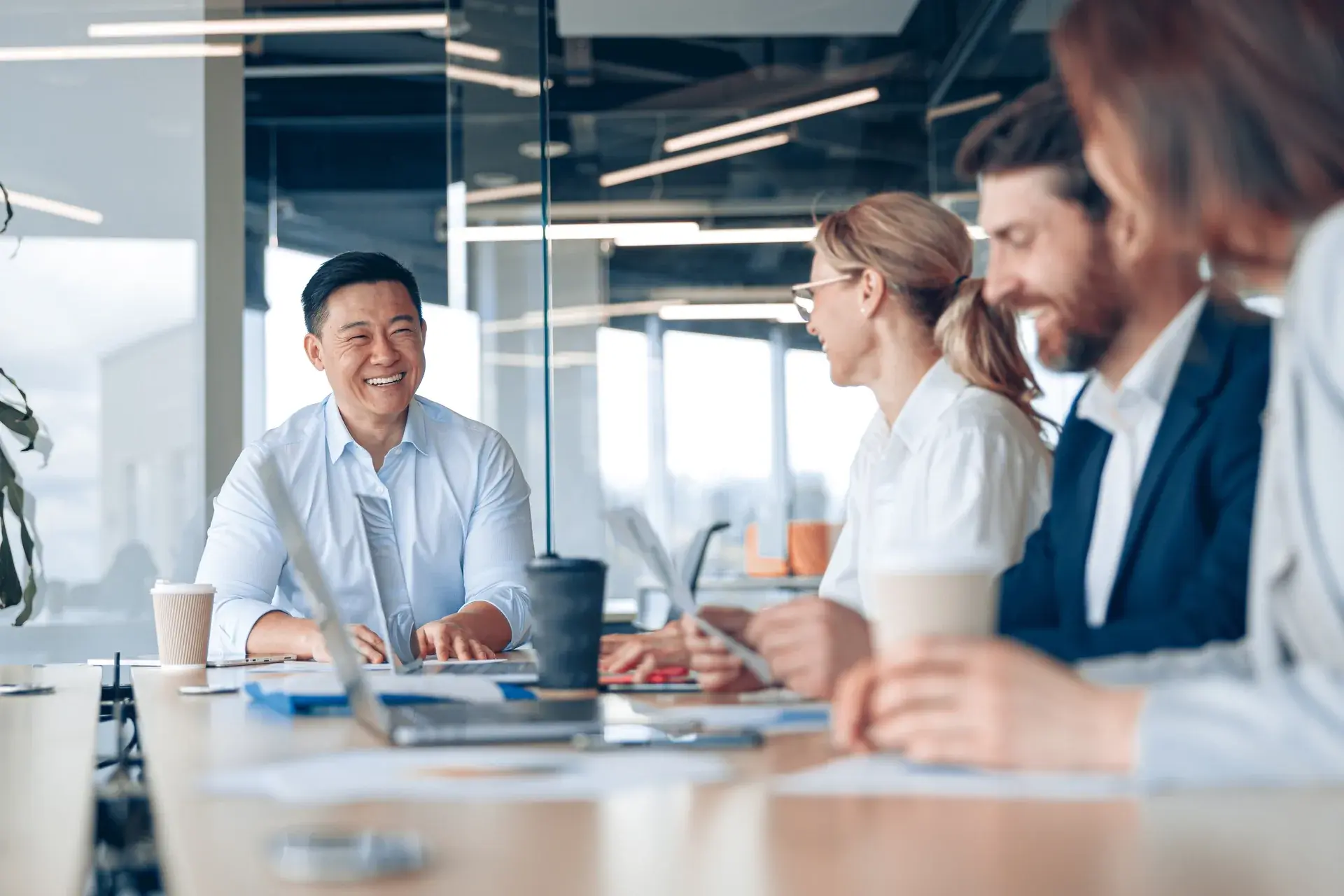 Colleagues reviewing content performance together at a table in a glass-walled office