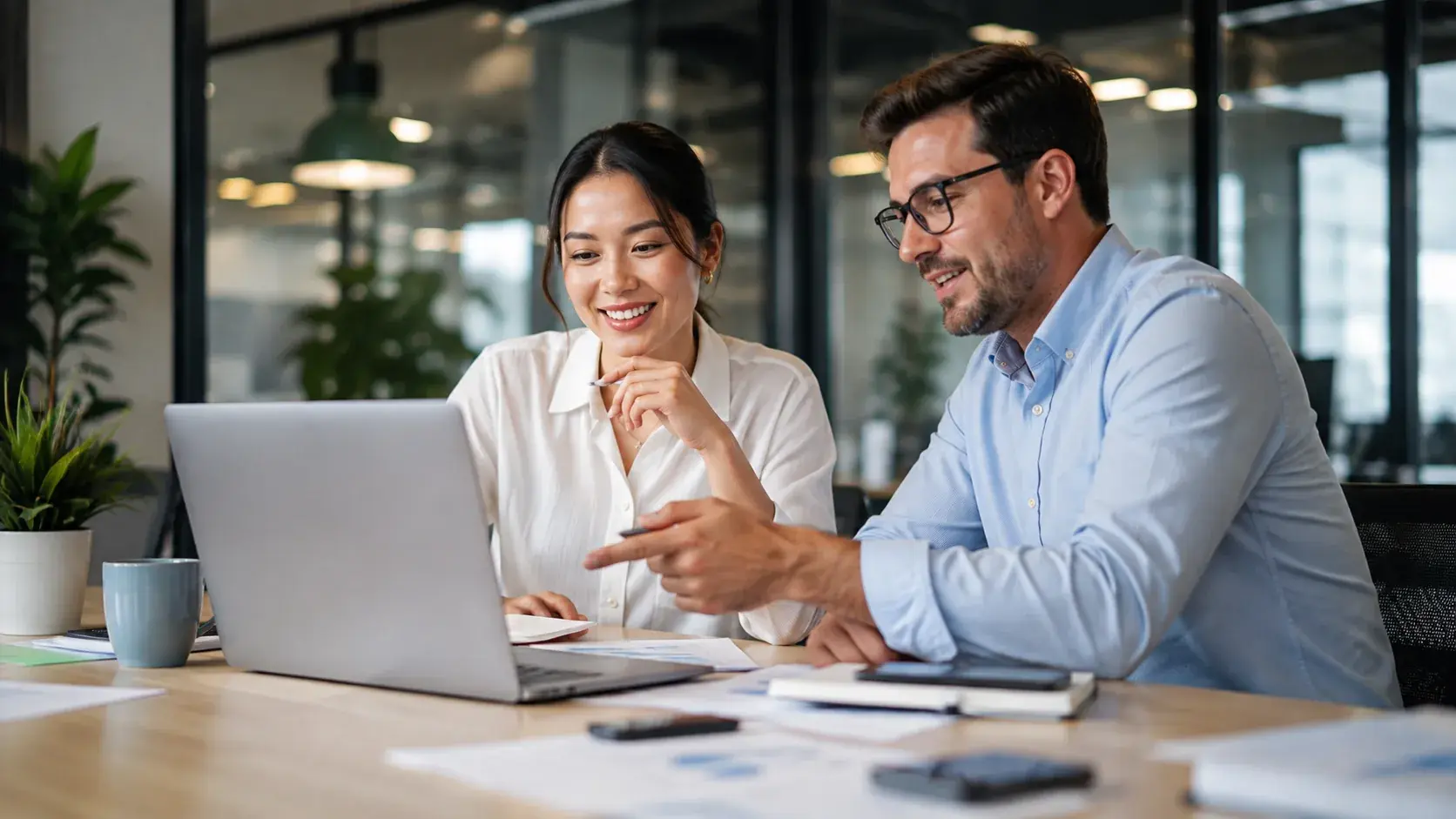 Two colleagues reviewing a customer rewards experience on a laptop