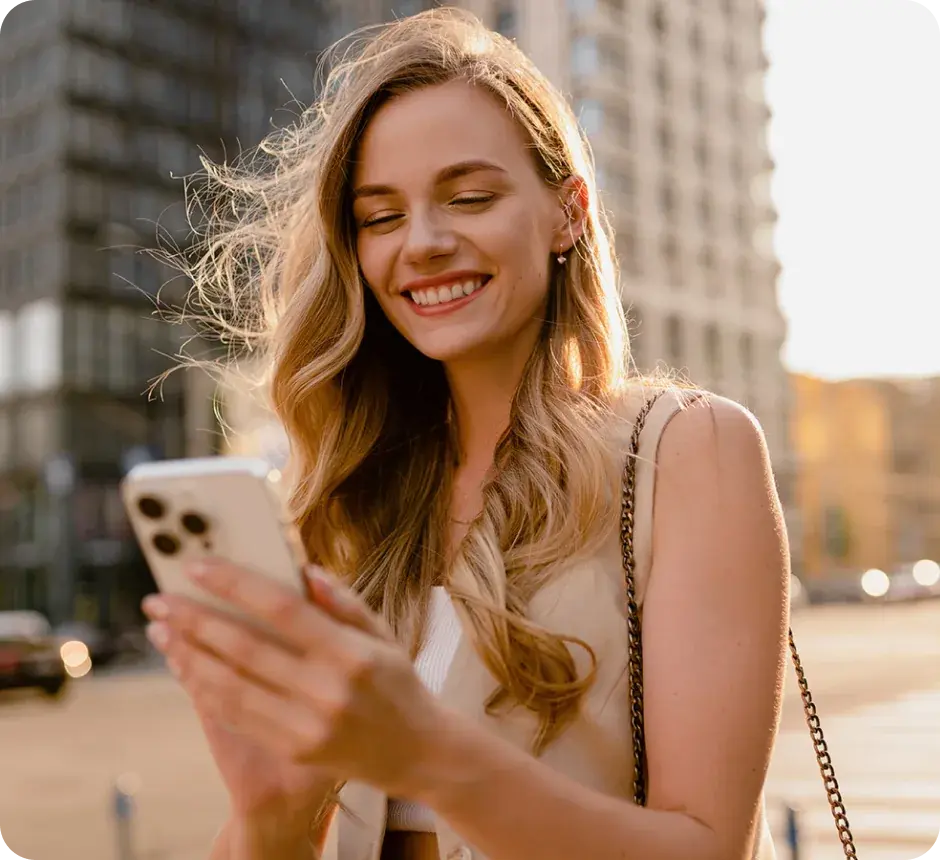 A shopper smiling at her phone on a city street